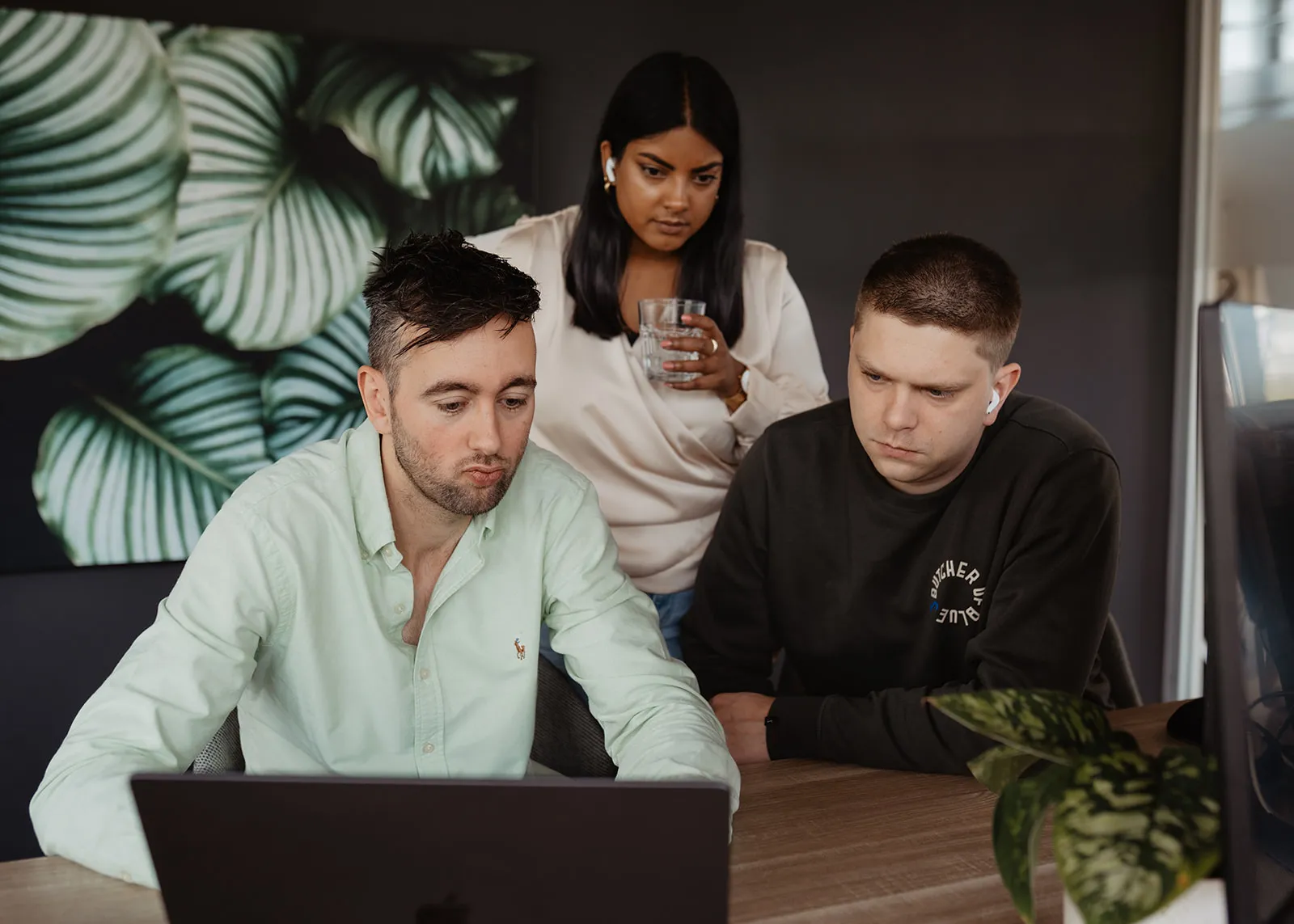 Het team van Coding.nl overlegt samen achter een laptop